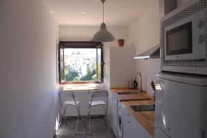 a small kitchen with a table and two stools at Buenavista Apartment in Ronda