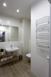 a white bathroom with a sink and a toilet at Dwie Sosny Apartamenty Ostrowski in Ustronie Morskie +60 photos