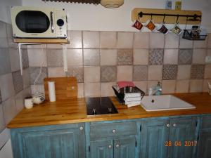 a kitchen counter with a sink and a microwave at Apartmány U Šakala in Zdíkov