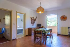 a dining room with a table and chairs and a bedroom at Appartamento Arancio in Procchio