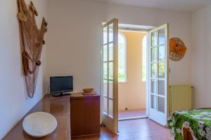 um quarto com uma televisão numa cómoda e uma porta em Appartamento Arancio em Procchio