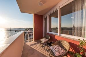 Un balcón con dos sillas y vista al agua. en Amazing View Apartment, en Zadar