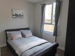 a small bedroom with a bed with a window at Turnpike House in London