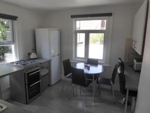 a kitchen with a stove and a table and a refrigerator at Turnpike House in London