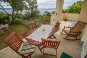 a patio with a table and chairs on a patio at Apartments Ivana in Ravni