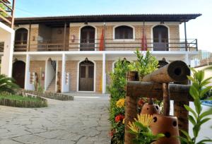 a brick house with a building with a balcony at Oxente Travel Apart Hotel in Natal