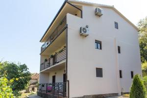 ein weißes Gebäude mit zwei Balkonen darauf in der Unterkunft Apartment Bambo Tre Sorrele in Kotor