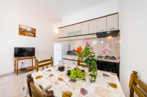- une cuisine avec une table et un vase de fruits dans l'établissement Apartment Čulina, à Pridraga