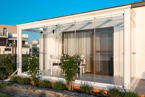 a glass extension of a house with a table at MobyDick Luxury Beach Apartment in Siófok +5 photos