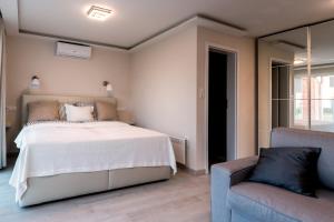 a bedroom with a large bed and a chair at MobyDick Luxury Beach Apartment in Siófok
