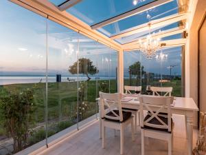 a dining room with a table and chairs and a large window at MobyDick Luxury Beach Apartment in Siófok