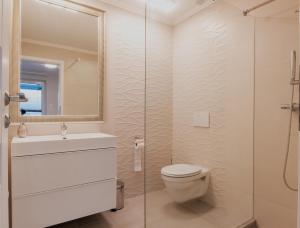 a bathroom with a toilet and a sink and a shower at MobyDick Luxury Beach Apartment in Siófok