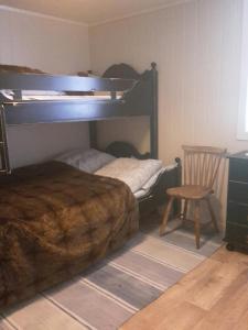 sypialnia z łóżkiem piętrowym i krzesłem w obiekcie Prima Lofoten w mieście Myrland