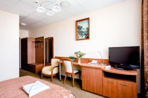 um quarto com uma secretária, uma televisão e uma cama em Hotel Stal em Stalowa Wola