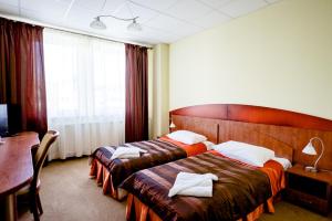 a hotel room with two beds with towels on them at Hotel Stal in Stalowa Wola