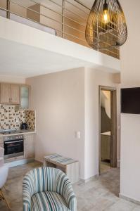 a living room with a chair and a kitchen at Arina Villa in Skala Marion