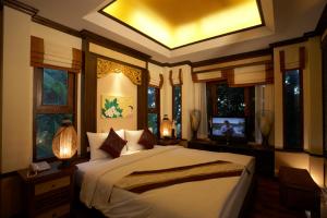 ein Schlafzimmer mit einem Bett und einem Fernseher in der Unterkunft Salad Buri Resort- SHA Extra Plus in Salad Beach