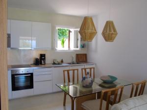 a kitchen with a table and a dining room at Seafront Calista Beach House With Garden in Glyfada