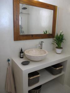 a bathroom with a sink and a mirror at Seafront Calista Beach House With Garden in Glyfada
