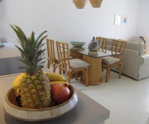 a bowl of fruit on a table in a living room at Seafront Calista Beach House With Garden in Glyfada