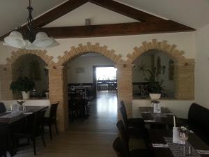 a dining room with arches and tables in a restaurant at Hotel Restaurant Platamon in Feuchtwangen