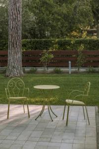 two chairs and a table and a table and chairs at Arli Hotel Hideaway Punta Ala - Adults Only in Punta Ala