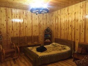 a bedroom with a bed and a wooden wall at Holiday Home Rayskiy Ugolochek in Kvitki