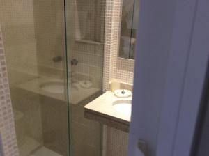 y baño con ducha acristalada y lavamanos. en Apartamento Copa Ipa 307, en Río de Janeiro