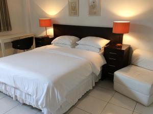 1 dormitorio con 1 cama blanca grande y 2 lámparas en Apartamento Copa Ipa 307, en Río de Janeiro