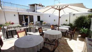 a patio with two tables and an umbrella at Crispi 10 in Floridia