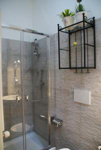 a bathroom with a glass shower with a sink at Rome Orange Inn in Rome