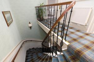 a flight of stairs with a plaid carpet at Sherwood Guest House in Edinburgh