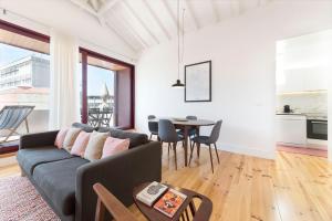 uma sala de estar com um sofá e uma mesa em LovelyStay - Top Floor Balcony Apartment no Porto