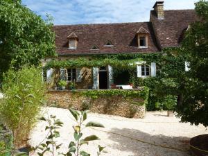 an old stone house with a stone wall at La vignolle in Saint-Amand-de-Coly