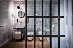 a bathroom with a sink and a toilet and a mirror at Teku Sardinia Boutique Hotel in Bari Sardo