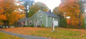 a green house with a sign in front of it at Truman Gillet House B & B in Granby