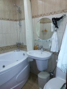 a bathroom with a sink and a tub and a toilet at Schastie na Rubinsteina - Apartments in Saint Petersburg