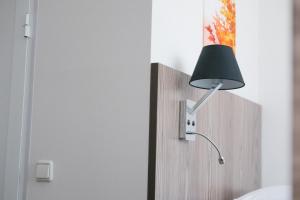 a lamp plugged into a wall next to a door at Sakura Inn in Fergana +41 photos