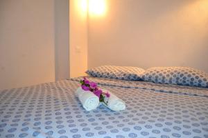 パンテレリアにあるDammuso Calypsoのベッドに座るタオルと花