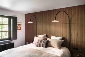 a bedroom with a large bed with a wooden headboard at Loft Living Garden Suite in Nieuwpoort