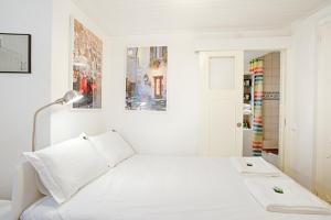 リスボンにあるBmyGuest - Mouraria Central Apartment IIの白いベッドルーム(ベッド1台、ランプ付)