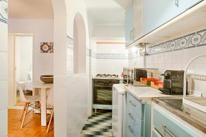 a kitchen with blue cabinets and a table at BmyGuest - Mouraria Central Apartment II in Lisbon