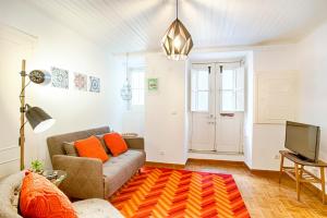 Una sala de estar con un sofá y un televisor. en BmyGuest - Mouraria Central Apartment II, en Lisboa