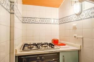cocina de azulejos blancos con fogones en BmyGuest - Mouraria Central Apartment II, en Lisboa