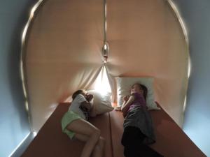 two girls sitting on a bed in a room at Camping le Mont Joli Bois in Criel-sur-Mer