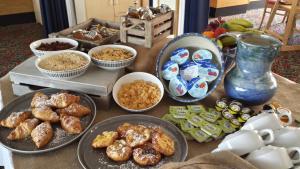 a table topped with plates of food and bowls of food at The Riviera Hotel & Apartments - Alum Chine in Bournemouth