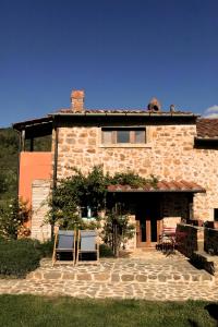 una casa de piedra con dos sillas delante en Podere di Maggio - Casa Grande, en Santa Fiora