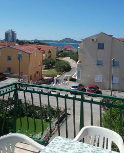 een balkon met een tafel en stoelen en uitzicht op een straat bij Apartman "Rosa" in Vodice