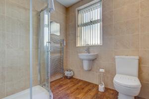 a bathroom with a toilet and a sink and a shower at New Boston Guest Accommodation in Fleetwood