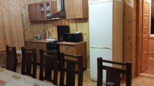 a kitchen with a table and chairs and a refrigerator at Holiday Home Rayskiy Ugolochek in Kvitki +45 photos